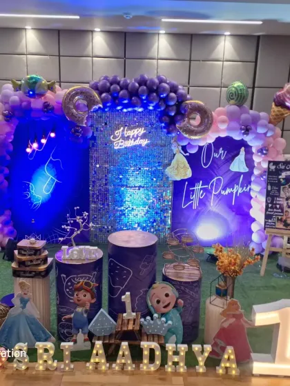 A fun Cocomelon and ice cream themed first birthday. The purple and blue color scheme is accented with donut and ice cream cone balloons and a bright shimmer wall.