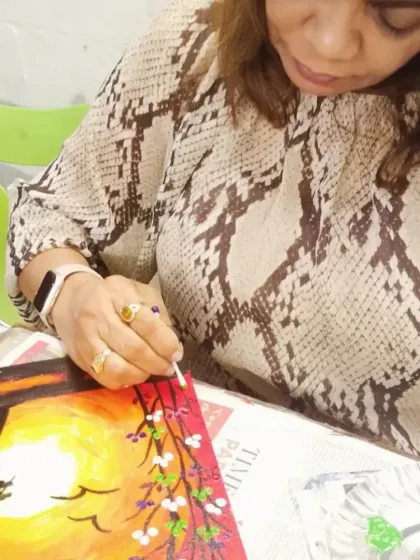 The process is just as important as the final piece. Here, a student is completely absorbed, adding fine details to her sunset painting with a cotton bud.