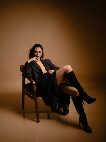 A powerful studio look combining an oversized blazer with knee-high boots. This type of styling is about creating a bold silhouette and conveying confidence, perfect for a fashion-forward client or a commercial campaign.