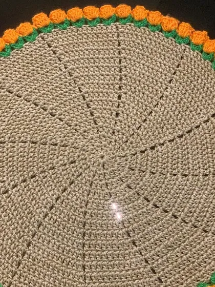 Another view of the beige doily with the orange tulip edge. It's a classic color combination that brings warmth to any table.