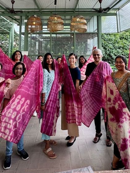 A happy group of women showing off the vibrant pink stoles they created. These workshops are a great way to connect with others while learning a new, sustainable skill.