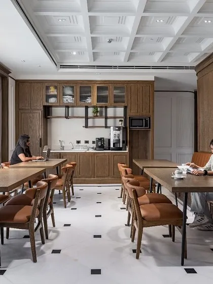 This image shows employees using the VRS office cafeteria, a space designed to be both functional and beautiful. The warm lighting and classic details create a comfortable atmosphere for breaks and informal meetings.