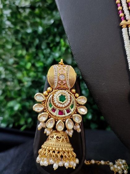 The matching earring for this set, featuring the same kundan and pearl design to complete your bridal ensemble.