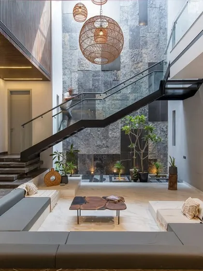 Inside the Casa Acentuada project, I designed this sunken lounge to be a tranquil heart of the home. The double-height space is anchored by a natural stone wall and a floating staircase, creating a dramatic interplay of light, volume, and texture.