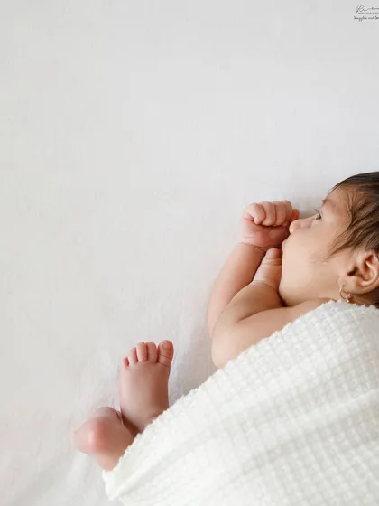 A close up shot of a newborn sleeping, with their tiny hand tucked under their chin. These are the details you'll want to remember forever.