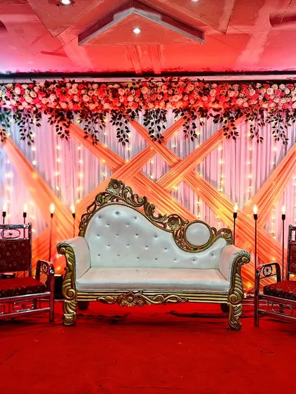 Another affordable stage option at just 12,000. This design features a classic white and gold sofa with a backdrop of draped fabric and floral arrangements.