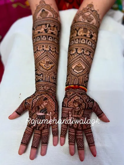 A beautiful example of bride and groom portraits on the palms. The rest of the design is filled with traditional motifs like elephants and paisleys, making the portraits stand out.