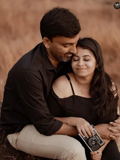 A tender moment from the same vintage camera themed shoot. The prop adds a personal touch, but the focus remains on the couple's emotion.