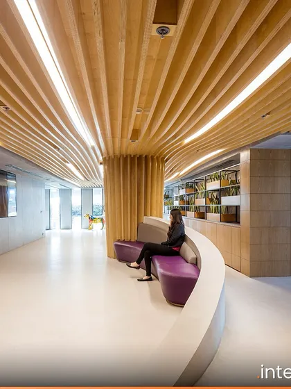 A flowing wooden ceiling element guides circulation through the Grant Thornton office. The design balances rugged industrial materials with sleek finishes, creating a dynamic and modern workplace that supports different modes of work.