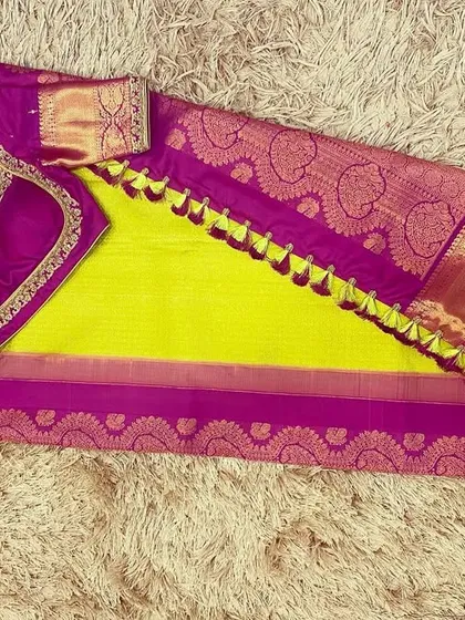 A vibrant combination of a neon green silk saree with a magenta purple hand-embroidered blouse. This bold pairing is perfect for making a statement.