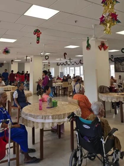 A wide shot of the performance hall, decorated for Christmas, shows the warm and festive atmosphere our students created for the residents.