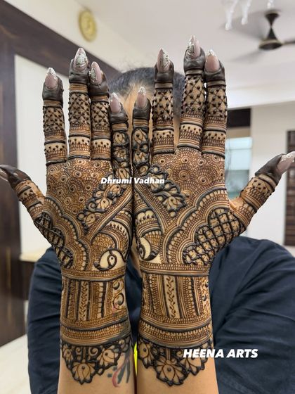 A beautiful example of Indian mehendi with fine lines, checkered patterns, and a central peacock design.
