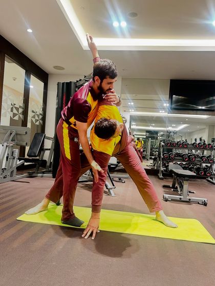 A different view of the Trikonasana adjustment, showing how I guide the rotation of the upper body for a fuller expression of the pose.