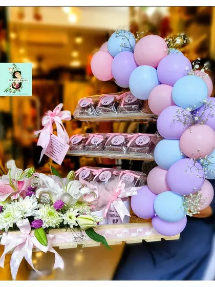 We were so excited to create this special hamper to celebrate the arrival of twins for the Ambani-Piramal family. This arrangement features a beautiful balloon cluster in pastel pink, blue, and purple, paired with a fresh floral display of lilies and chrysanthemums. A tiered stand of delicious brownies adds a sweet touch to this grand welcome gift.