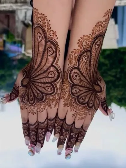 An artistic take on the classic peacock, with the feathers fanning out to cover the entire back of the hand.