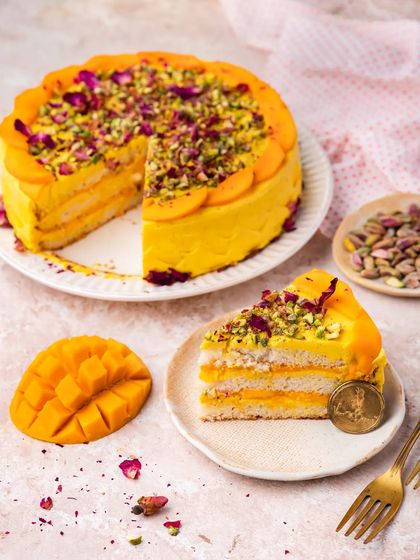 Our AamRasmalai Cake is a unique fusion dessert. We infuse rasmalai creme with homemade aamras and layer it with vanilla sponge, fresh mangoes, pistachios, and rose petals.