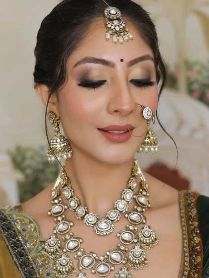 A detailed close-up of the eye makeup, a beautiful blend of gold and brown tones for a classic bridal look.