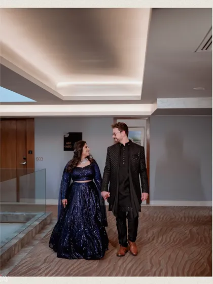 A classic walking portrait of the couple in a hotel corridor. Their coordinated navy blue outfits and happy gazes create a simple yet elegant image.