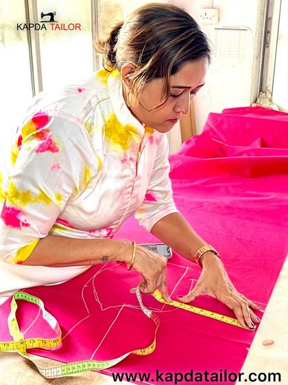The art of tailoring. Here I am, carefully measuring and marking a vibrant pink fabric, ensuring every detail is perfect before the first cut is made.