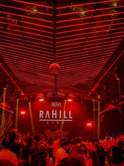 The interior of Xora Hyderabad, bathed in red light for a live DJ set. I transform venues with dynamic lighting design that syncs with the music to create an intense atmosphere.