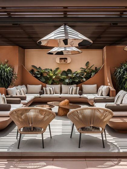 A frontal view of the main seating lounge, designed for comfort and conversation. The built-in, curved sofas follow the organic lines of the space, while custom-designed pendant lights add an artistic, sculptural element.