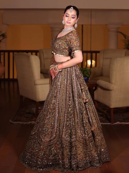 Designer outfits at a fraction of the price. A full-length shot of a model in a stunning antique gold lehenga, perfect for a royal-themed wedding.