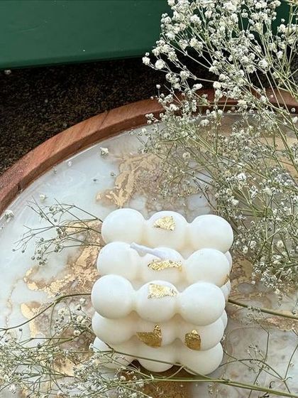 The bubble candle, styled on a decorative tray with baby's breath. This image shows how it can be used as a chic decorative object in your home.
