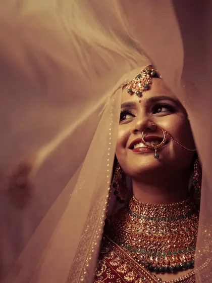 The timeless beauty of a bride, captured in a moment of quiet joy. This portrait, with the delicate veil and soft lighting, is an example of how we create elegant and emotional bridal shots that you will cherish forever.