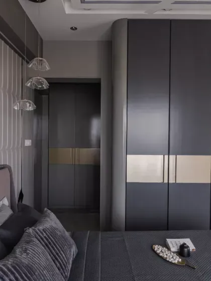 Sophisticated and timeless, this master bedroom is a seamless fusion of luxury and functionality. The deep-toned wardrobes with gold accents create a bold, elegant statement, while the textured paneling adds depth and character.