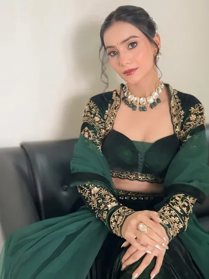 A seated portrait showing the intricate embroidery on the jacket and the beautiful harmony between the makeup and the outfit.