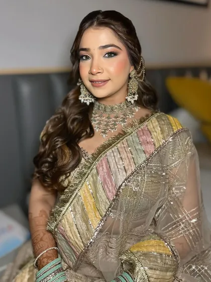 A beautiful look for a Jaggo night. The makeup is glamorous, with a focus on the eyes, and the hair is styled in soft waves with a unique accessory.