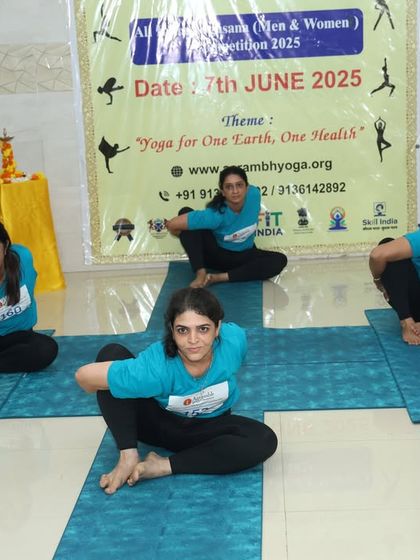 Participants in the group competition holding a synchronized Marichyasana C twist. Precision and timing are key in these events, and this team demonstrates perfect unison.