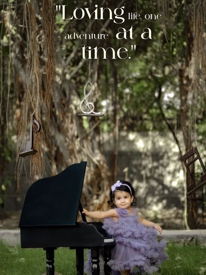 Loving life, one adventure at a time. A girl in a purple dress stands by her piano under a beautiful banyan tree.