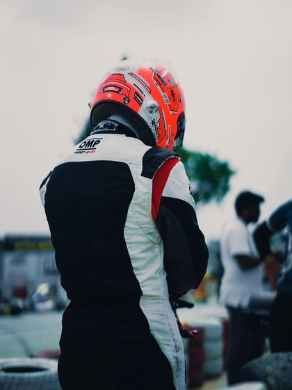 A driver standing in the pit area.