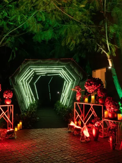 We love creating a dramatic first impression. This illuminated tunnel entrance, lined with bold red floral arrangements, set the tone for a glamorous 'Golden Gala' sangeet, promising a night of high energy and unforgettable moments.