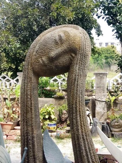 A bold sculpture can serve as the centerpiece of your garden. This large, abstract fiber-resin statue is lightweight, weatherproof, and adds a unique artistic touch to the outdoor landscape.