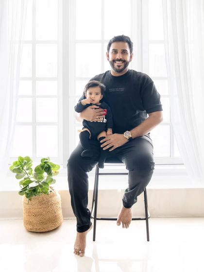 A handsome father and his baby girl. A classic father-daughter portrait against a clean, bright background.