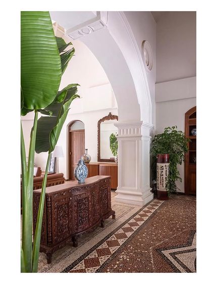 A detail shot showing a restored antique credenza against a structural arch. This highlights our commitment to preserving and showcasing the original grain and craftsmanship of the building.
