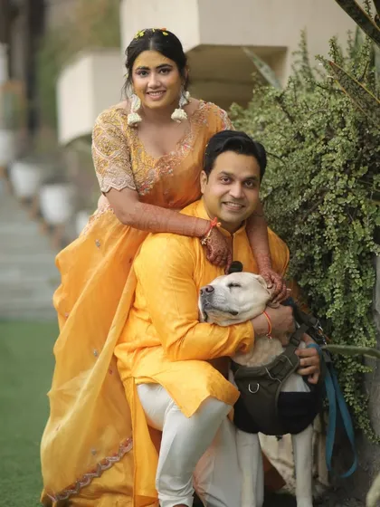 The couple poses with their beloved dog, making sure their furry family member is part of the celebration.