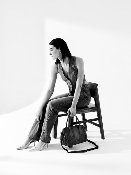 A minimalist black and white fashion shot for Kompanero. The clean lines and seated pose create a chic and sophisticated look.