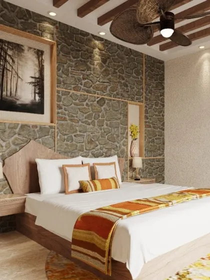 The bedroom interior at our Kanha project, featuring a stone accent wall and a leaf-inspired ceiling fan. The design aims to create a revitalizing sanctuary that integrates with the surrounding greenery.