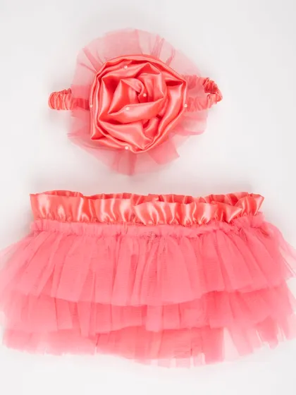 A coral-colored satin and tulle skirt and headband set for babies.
