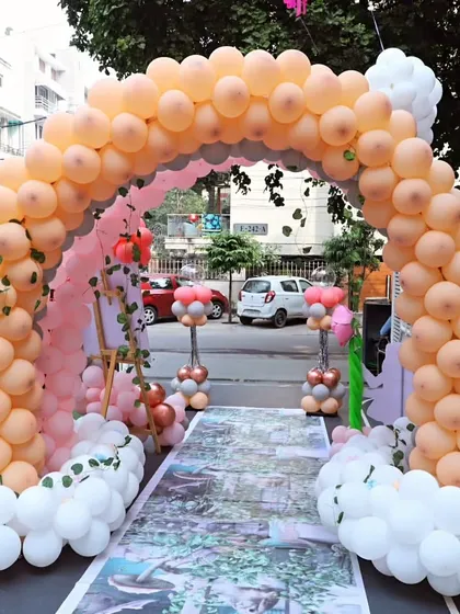 The entrance to a lovely fairy-themed party, with a custom printed walkway and a pastel balloon arch.