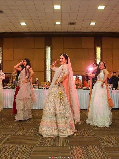 A beautiful shot of the bride and her bridesmaids during their surprise performance. The joy and coordination are perfectly captured in this moment.