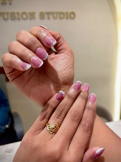 A beautiful blend of classy and glam. This look features a soft mauve base with a delicate glitter fade and a crisp white French tip.