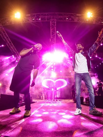 A fisheye lens shot captures the epic scale of the Mithoon Live stage at BBD University, Lucknow, with multiple artists performing together.