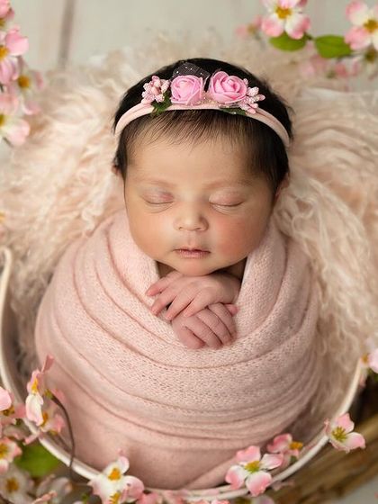 This little one is the center of a beautiful cherry blossom arrangement. The soft pink wrap and matching flowers create a perfectly coordinated and delicate portrait.