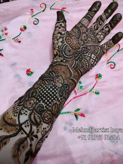 This full-arm design combines multiple patterns, including florals, paisleys, and a classic checkerboard filler, showcasing a wide range of henna techniques.