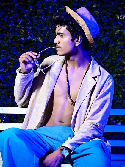 A seated portrait taken during a fashion event, using atmospheric lighting to create a cool, edgy mood. This style of photography is perfect for capturing behind-the-scenes moments or designer lookbooks with a distinct vibe.
