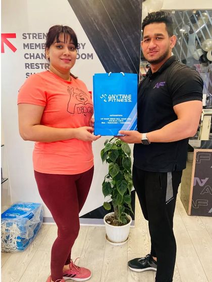 A happy member receives her anniversary gift from one of our trainers. Thank you for being part of our family.